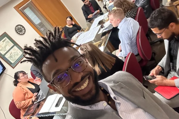 A smiling man taking a selfie with his professional team during a productive corporate marketing meeting or brainstorming session.